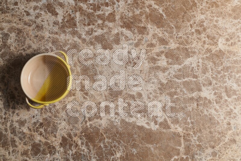 A multicolored pottery bowl on beige marble background