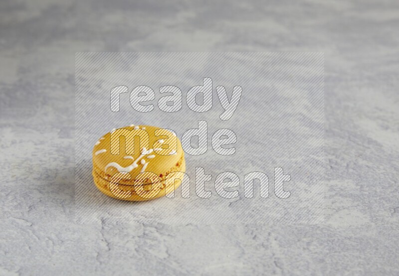 45º Shot of Yellow Piña Colada macaron on white  marble background