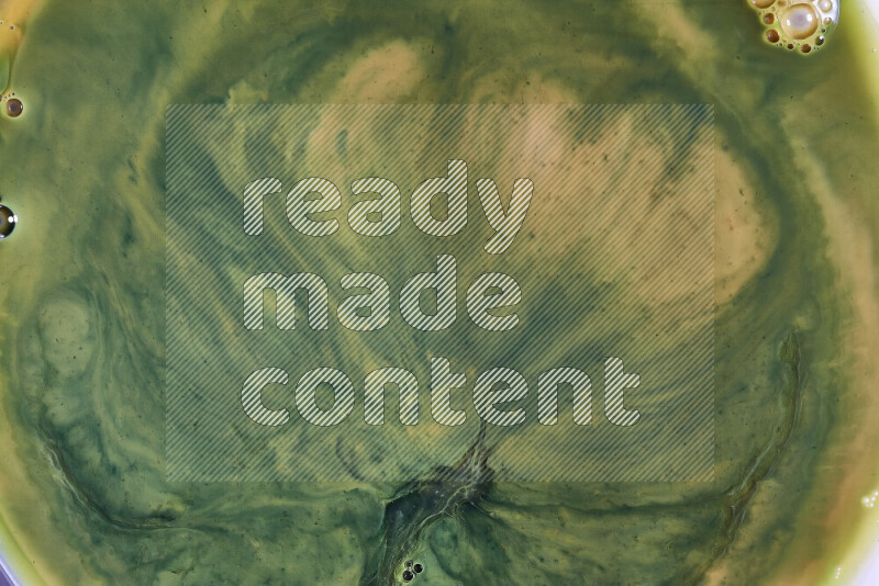 A close-up of abstract swirling patterns in orange and green