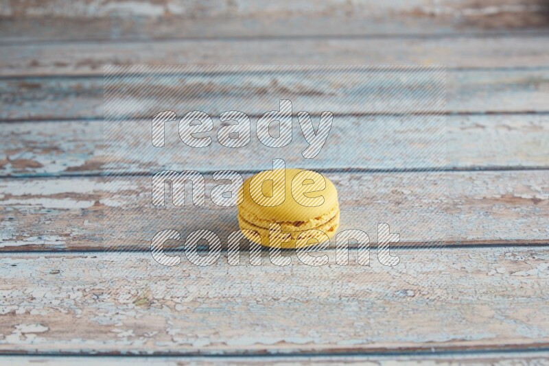 45º Shot of Yellow Lemon macaron on light blue wooden background