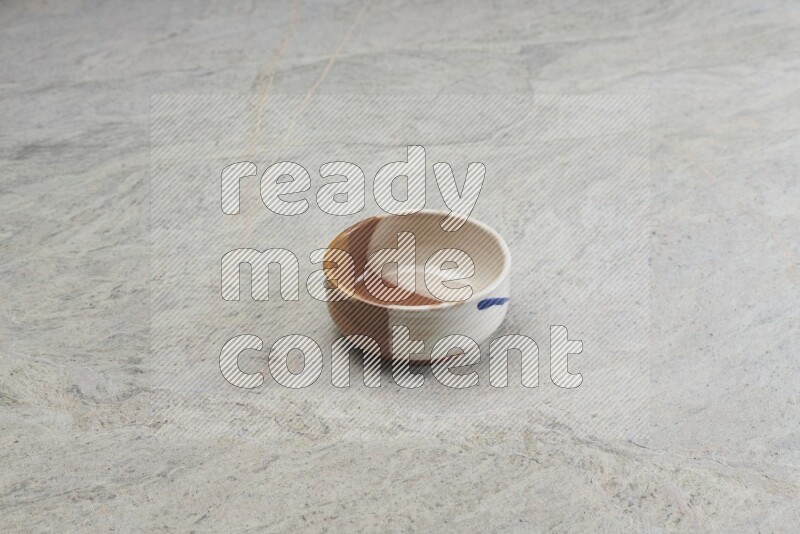 A multicolored pottery bowl on grey marble background