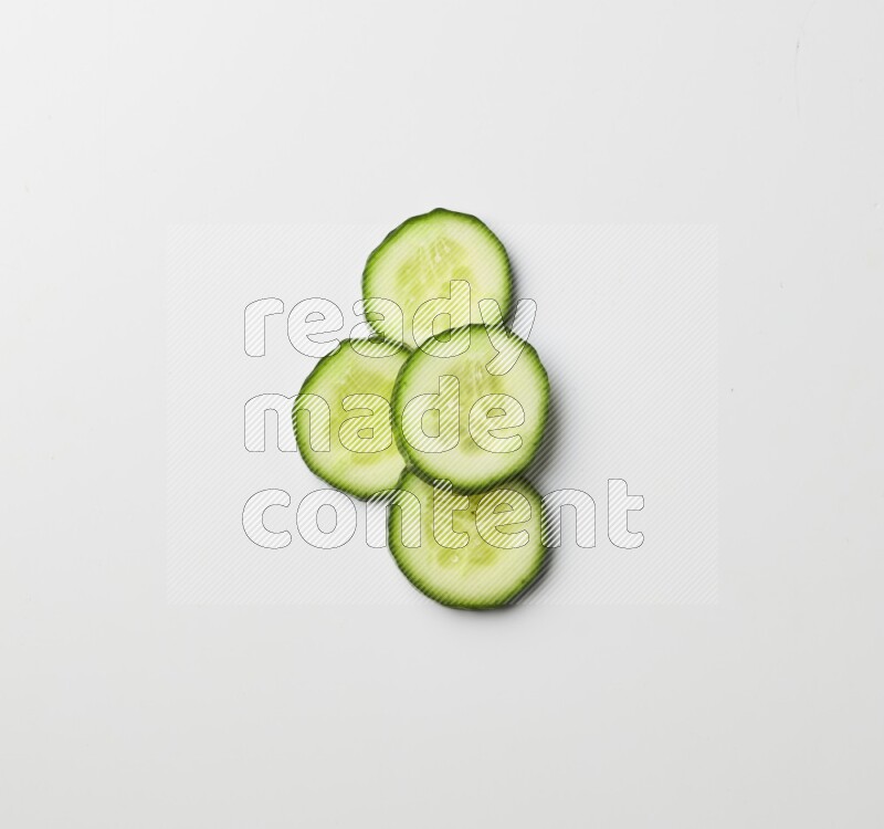 Multiple cucumber slices on white background