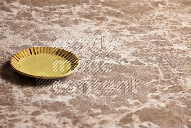A multicolored pottery plate on beige marble background