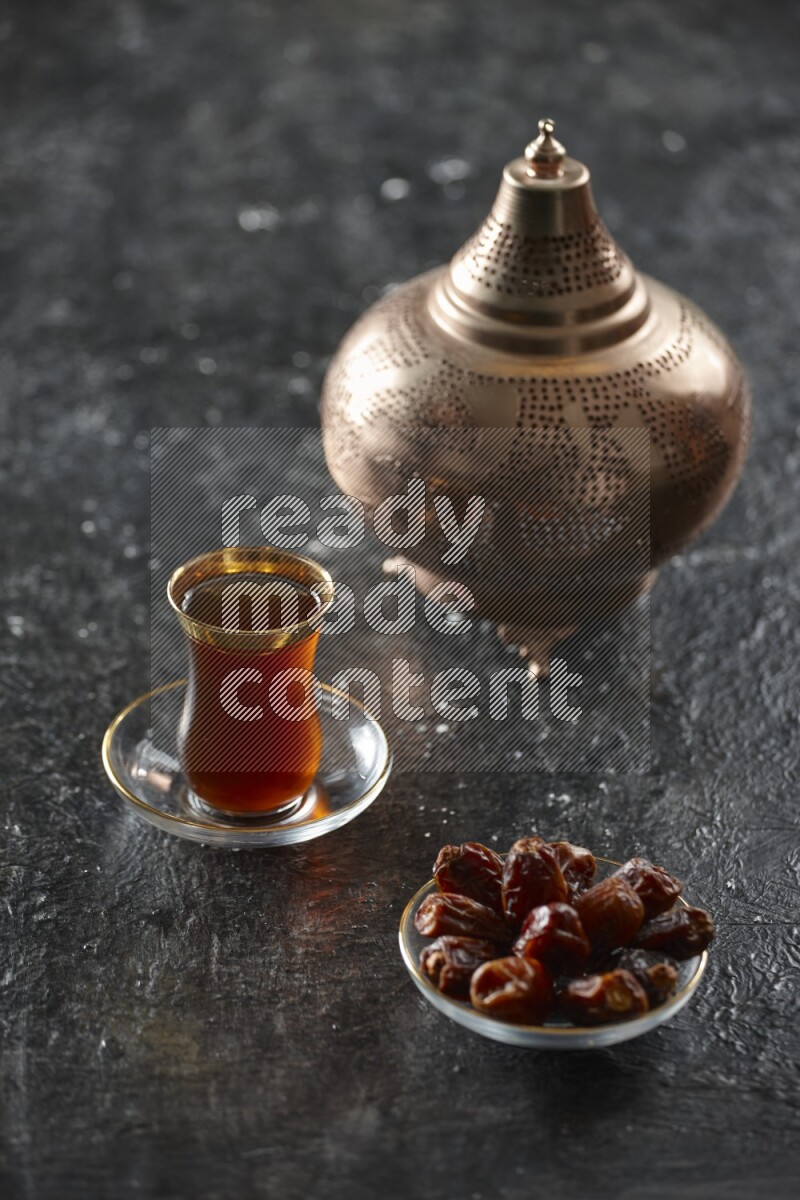 A golden lantern with different drinks, dates, nuts, prayer beads and quran on textured black background