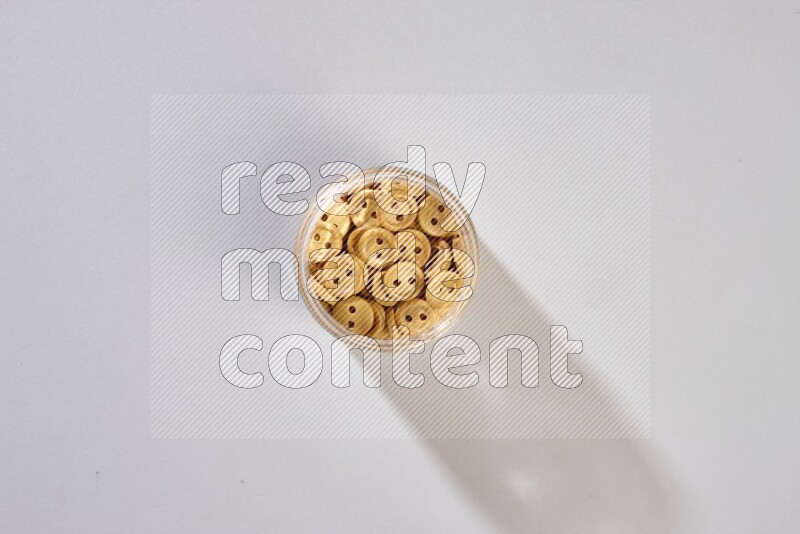 Colored buttons in a glass jar on grey background