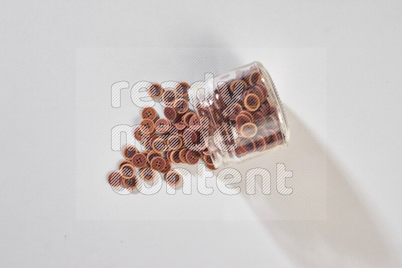 Colored buttons in a glass jar on grey background