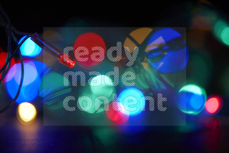 Light bulbs glowing against backdrop of multicolord bokeh