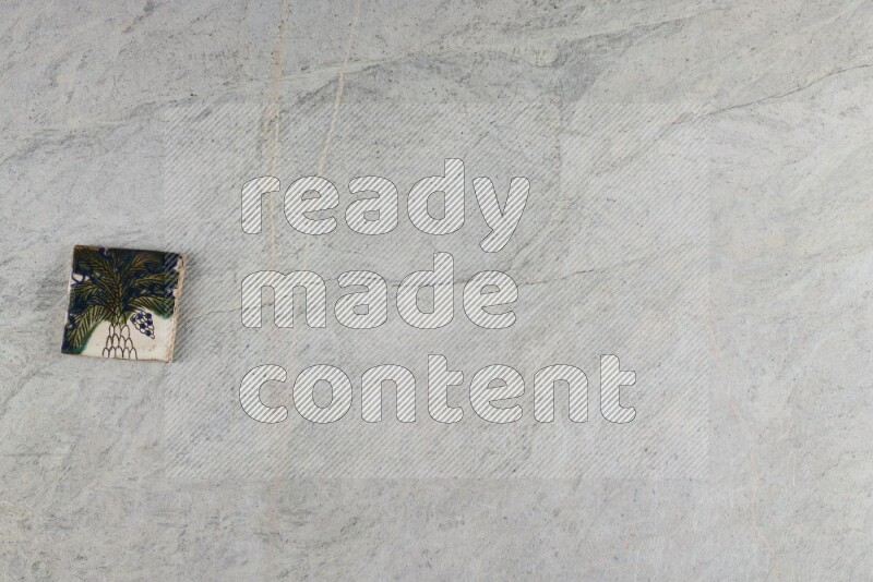 A decorative pottery coaster on grey marble background