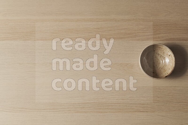 A multicolored pottery bowl on light wooden background