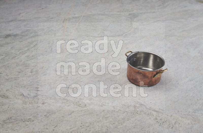 A small copper pot on grey marble background