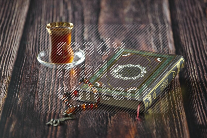 Quran with dates, prayer beads and different drinks all placed on wooden background