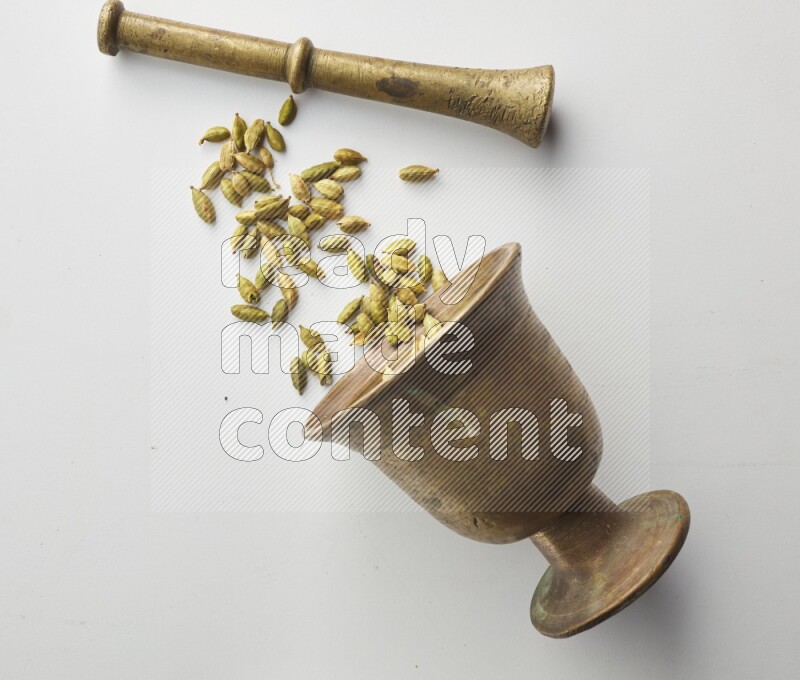 Top-view shot of Cardamon in herbs crusher on white background