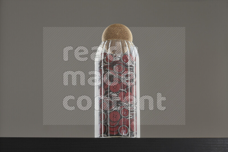 Buttons in a glass jar on black background