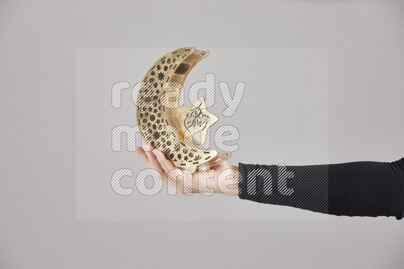 A woman in black abaya holding different ramadan lanterns in different positions
