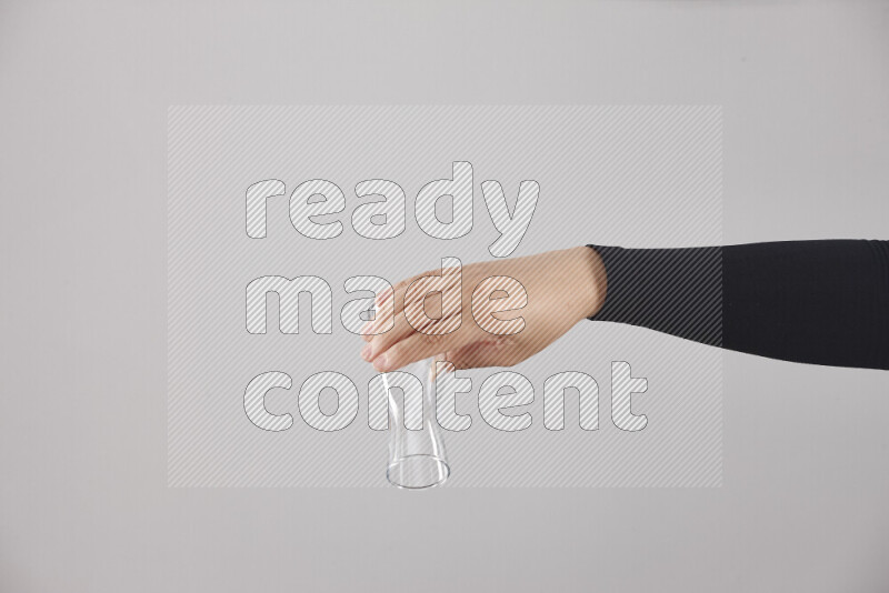 امرأة ترتدي عباءة سوداء تحمل أدوات زجاجية مختلفة في أوضاع متعددة