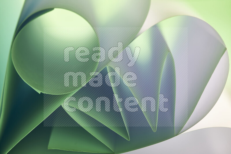 An artistic display of paper folds creating a harmonious blend of geometric shapes, highlighted by soft lighting in green and red tones