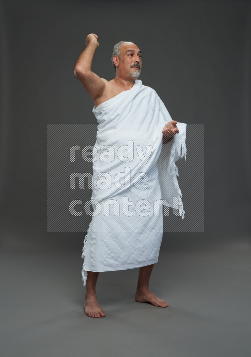A man wearing Ehram Standing Interacting with the camera on gray background