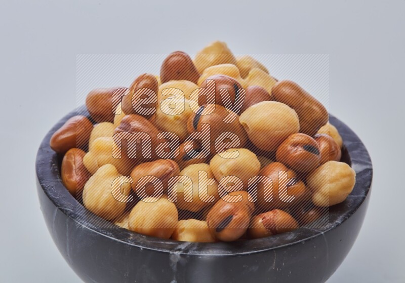 Close up shot of cooked fava beans (foul) & chickpeas on white background