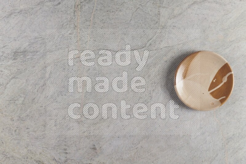 A multicolored pottery plate on grey marble background