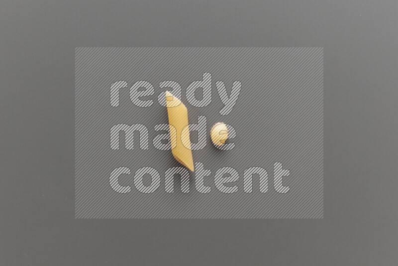 Penne pasta with other types of pasta on grey background