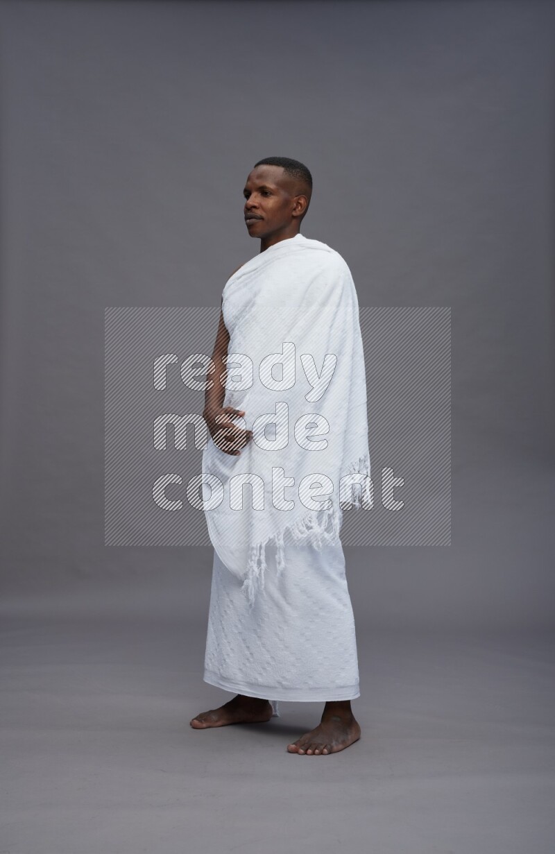 A man wearing Ehram Standing Interacting with the camera on gray background