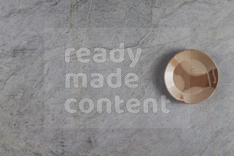 صحن فخاري متعدد الألوان على خلفية من الرخام الرمادي