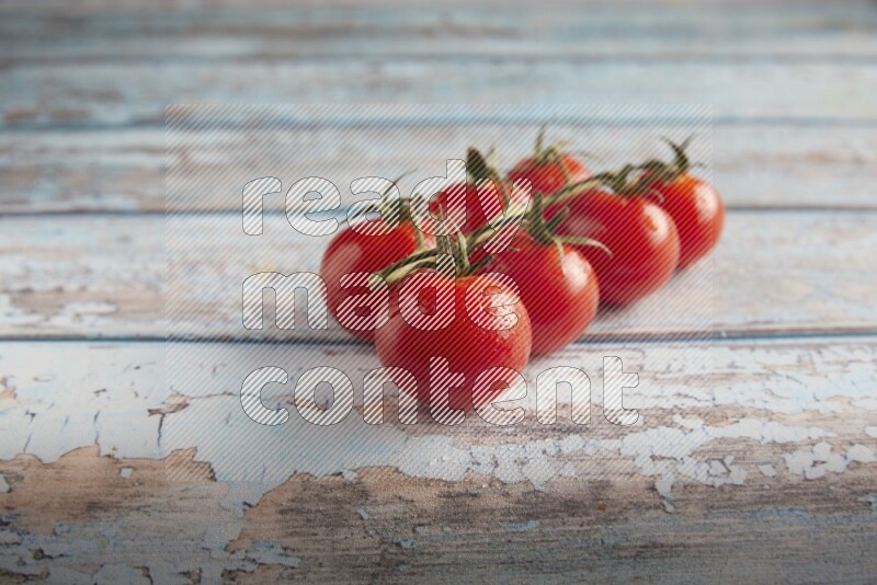 Red cherry tomato vein on a textured blue wooden background 45 degree