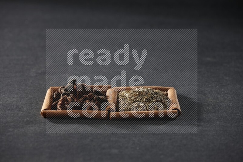 2 squares of cinnamon sticks full of cumin and star anise on black flooring