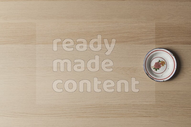 صحن معدني عتيق على خلفية خشبية فاتحة