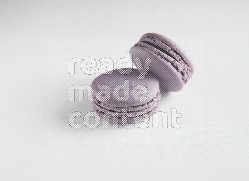 45º Shot of two Purple Blueberry macarons on white background