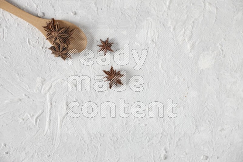 Star Anise in a wooden spoon on white flooring