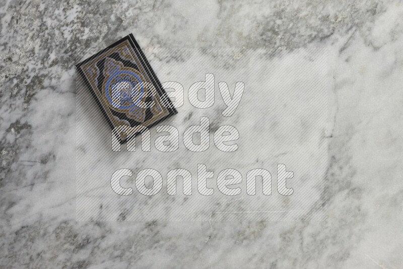 Quran with a prayer beads on grey marble background