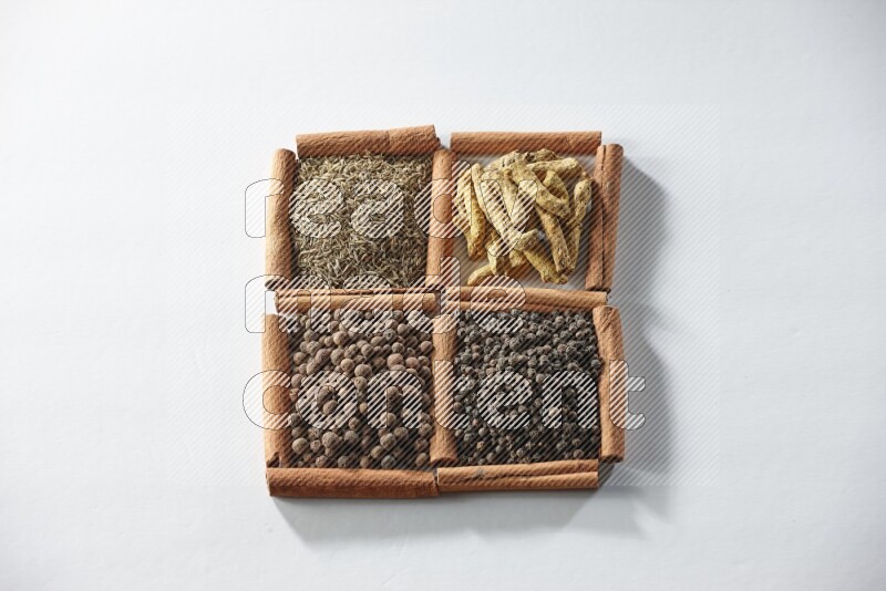 4 squares of cinnamon sticks full of cumin, turmeric fingers, allspice and black pepper on white flooring