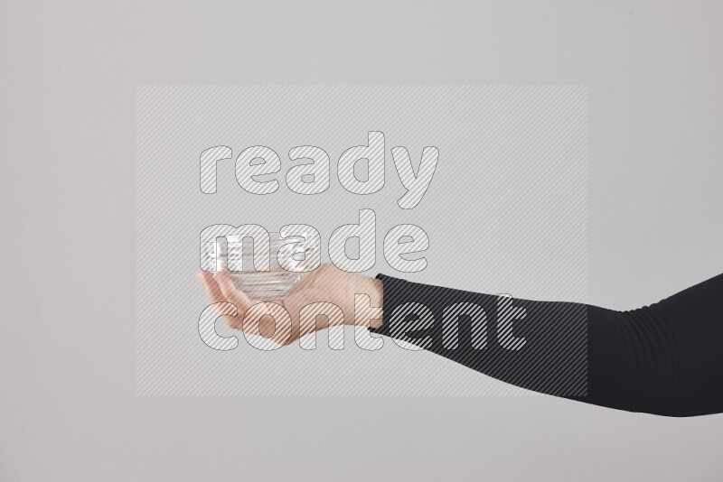 A woman in black abaya holding different glassware in different positions