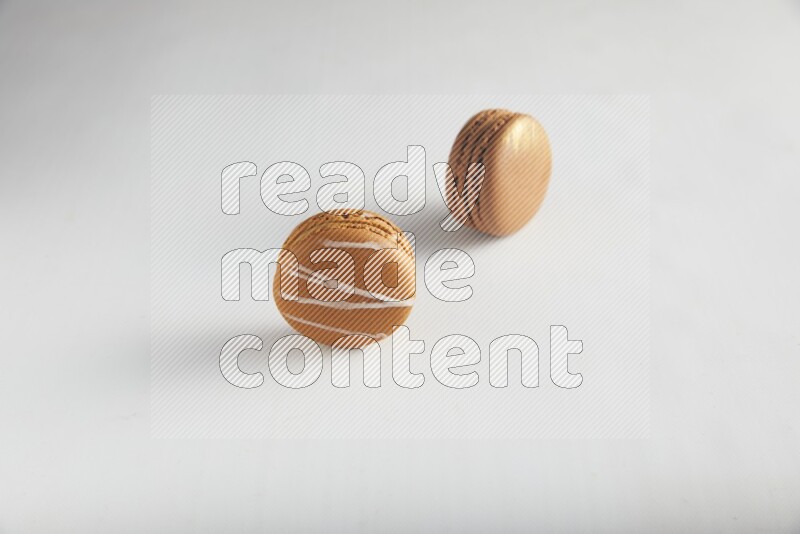 45º Shot of of two assorted Brown Irish Cream, and Brown Coffee macarons  on white background