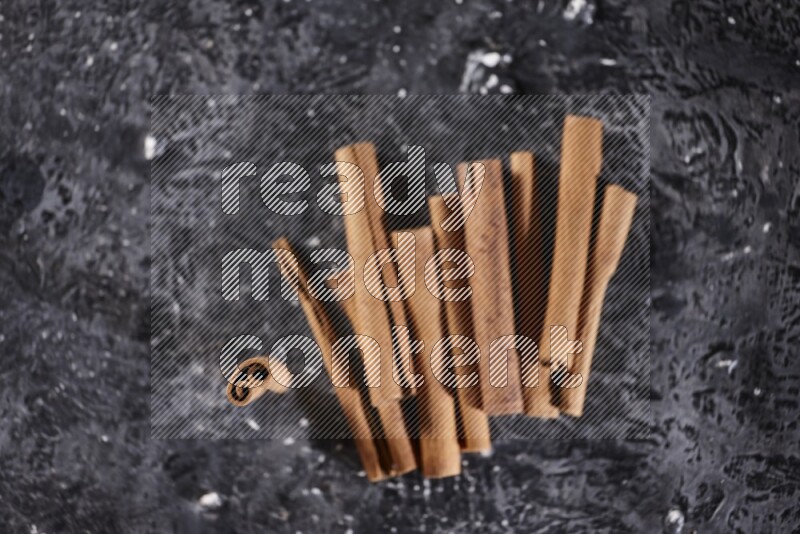 Cinnamon sticks on a textured black background