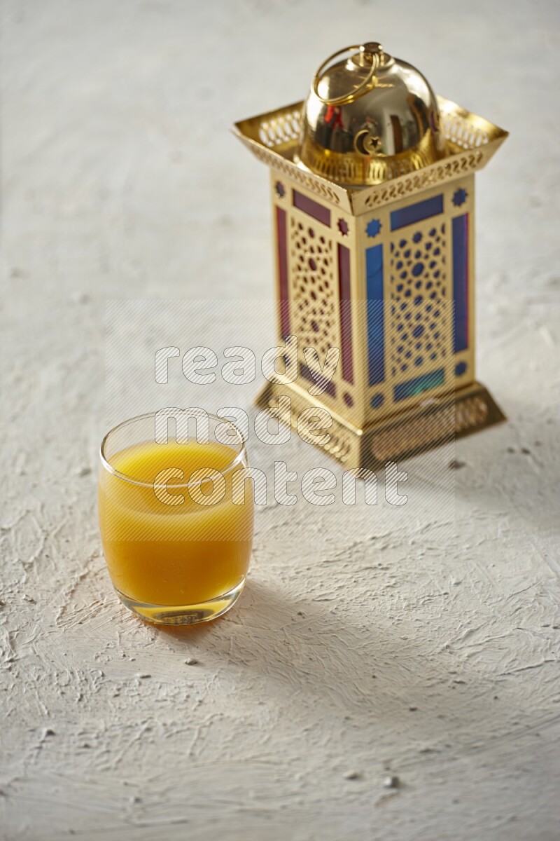 A golden lantern with different drinks, dates, nuts, prayer beads and quran on textured white background