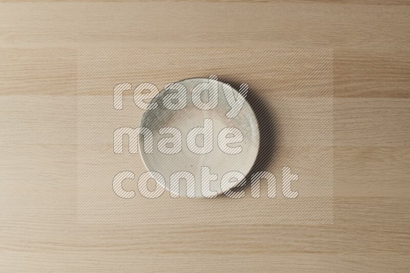 A multicolored pottery plate on light wooden background