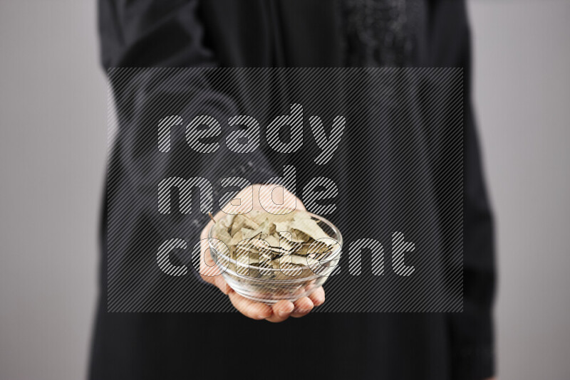 Woman in abaya holding different kinds of spices in different positions
