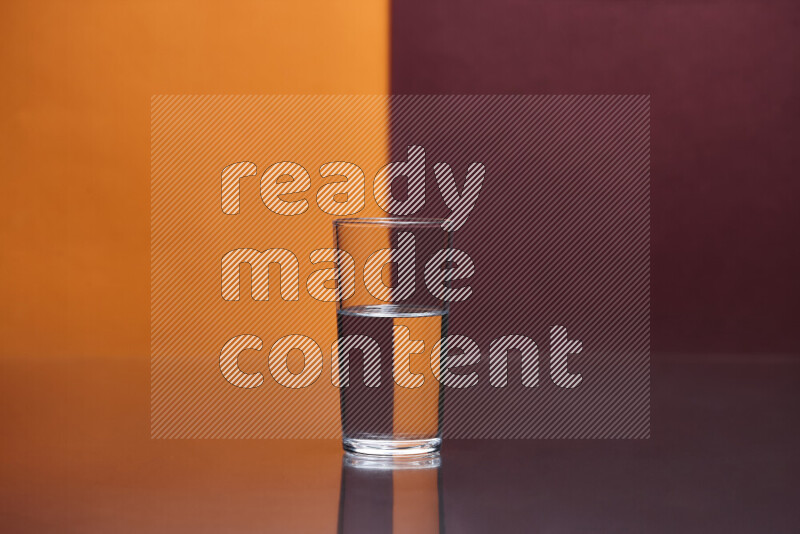 The image features a clear glassware filled with water, set against orange and dark red background