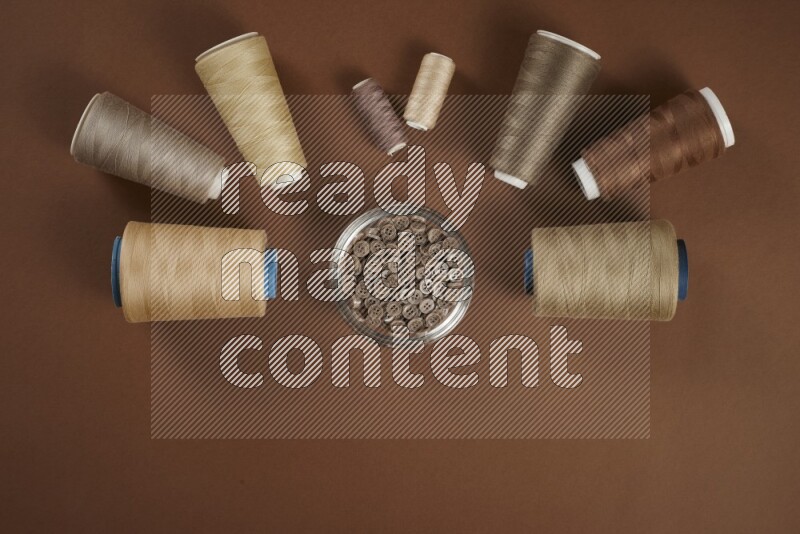 A brown collection of sewing and tailoring tools arranged on a brown background