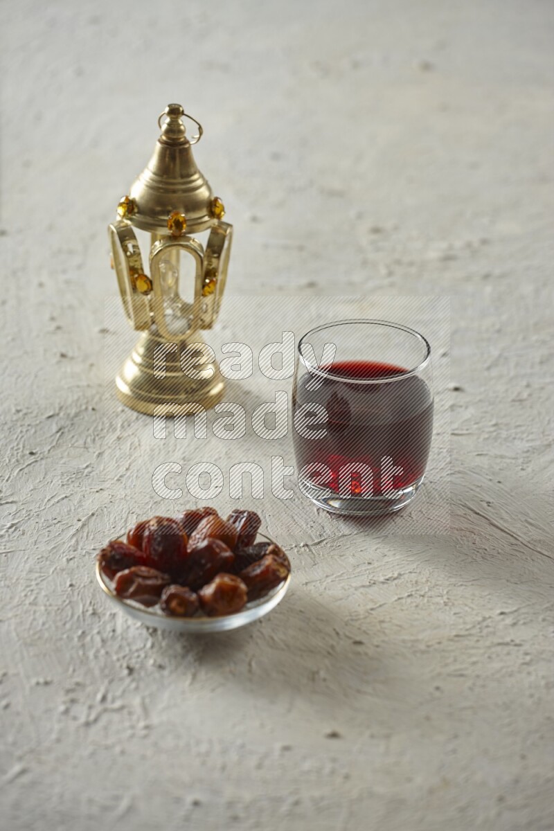 A golden lantern with different drinks, dates, nuts, prayer beads and quran on textured white background