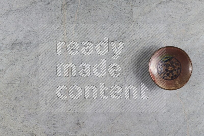 A decorative pottery plate on grey marble background