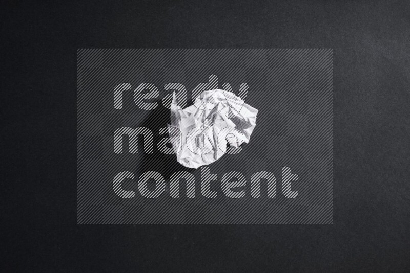 Crumpled notebook sheet on black background