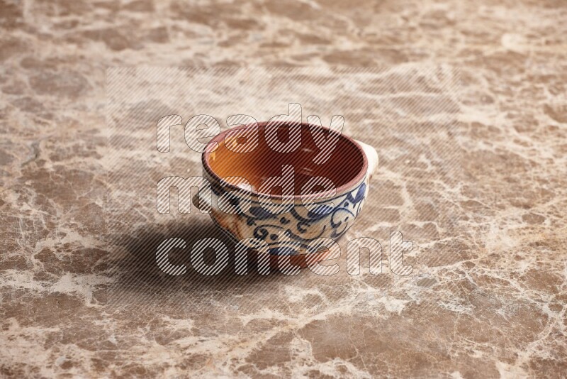 A decorative pottery bowl on beige marble background