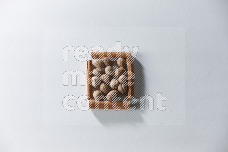 A single square of cinnamon sticks full of nutmeg on white flooring