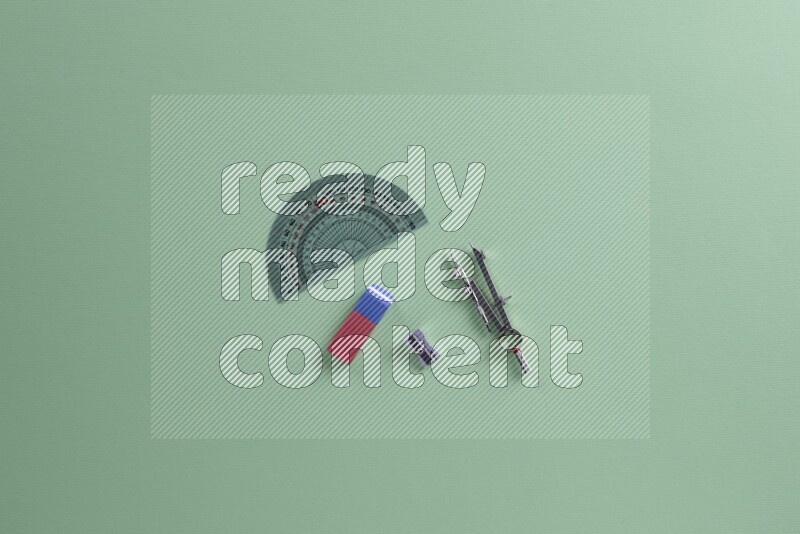 Different school supplies on green background