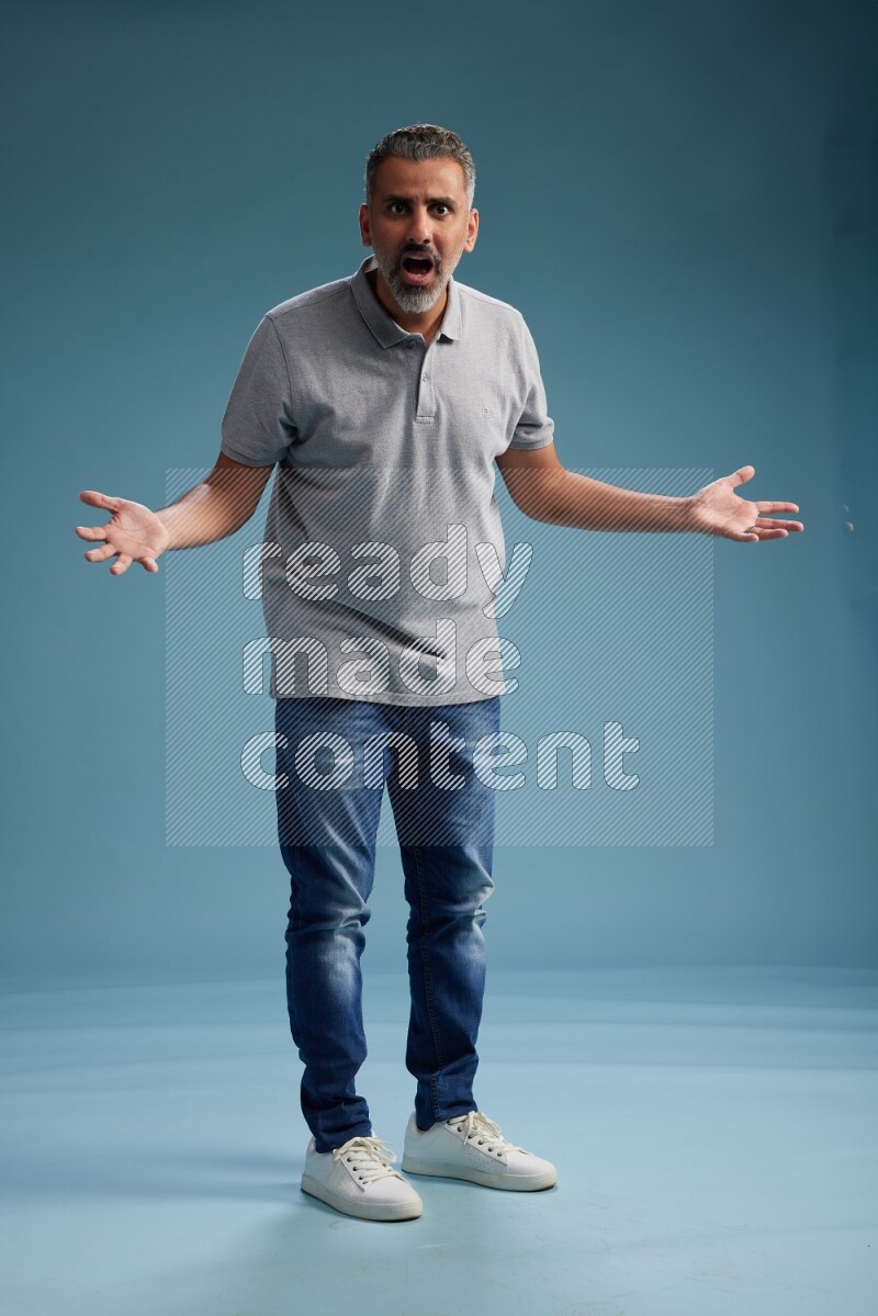Man Standing Interacting with the camera on blue background