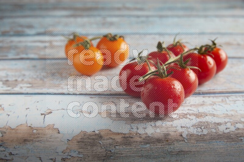 Mixed cherry tomato veins on a textured light blue wooden background 45 degree