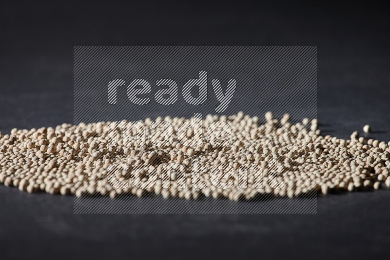 White pepper beads on black flooring